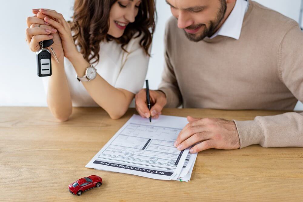 Couple signing a car finance agreement contract