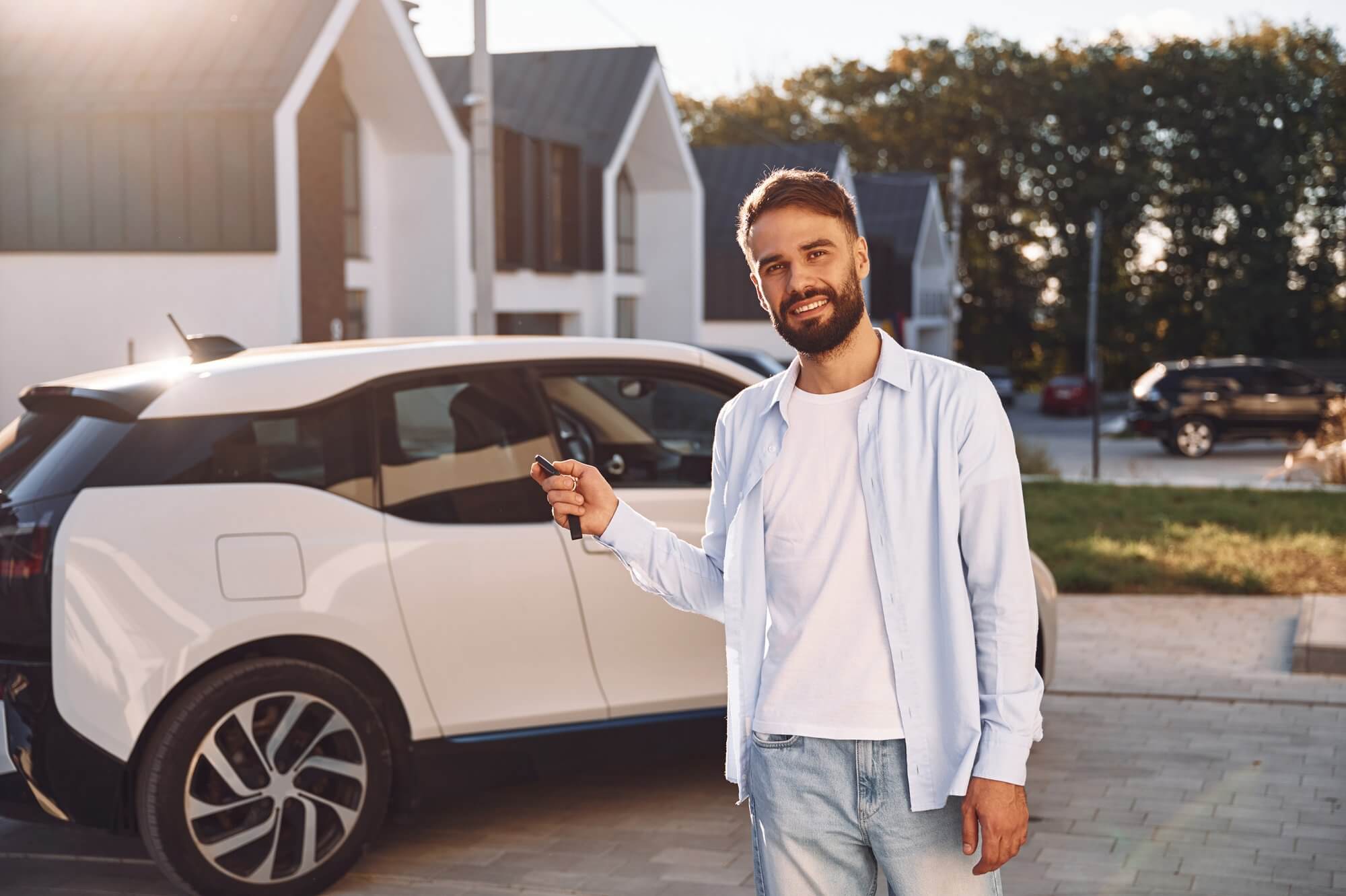 Man standing by car holding keys