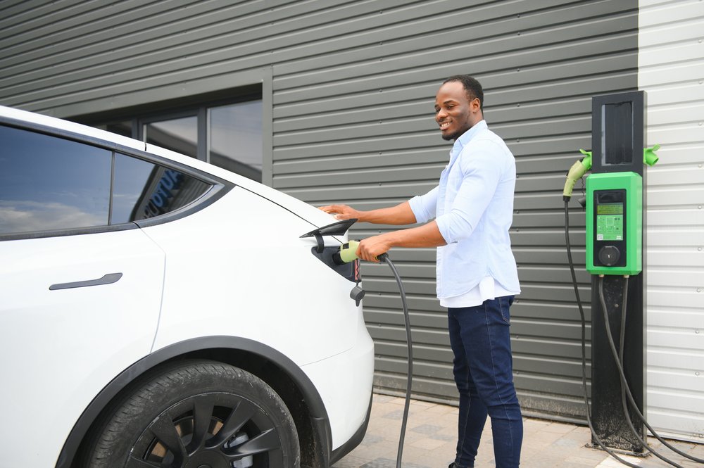 Man plugging his electric vehicle in to charge